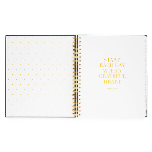 Open spiral-bound planner with polka dot pages foil printed with "start each day with a grateful heart"