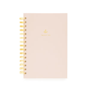Blush pink planner with gold spiral binding with twenty-six on the cover and a god flower