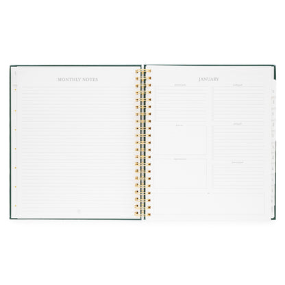 Open large weekly spiral-bound planner showing monthly notes and goals for January 2026