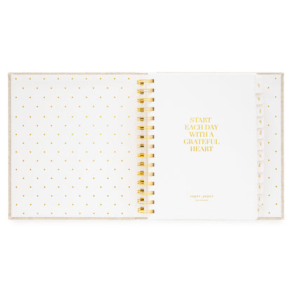 Interior of open concealed agenda with title quote of "start each day with a grateful heart" in gold foil