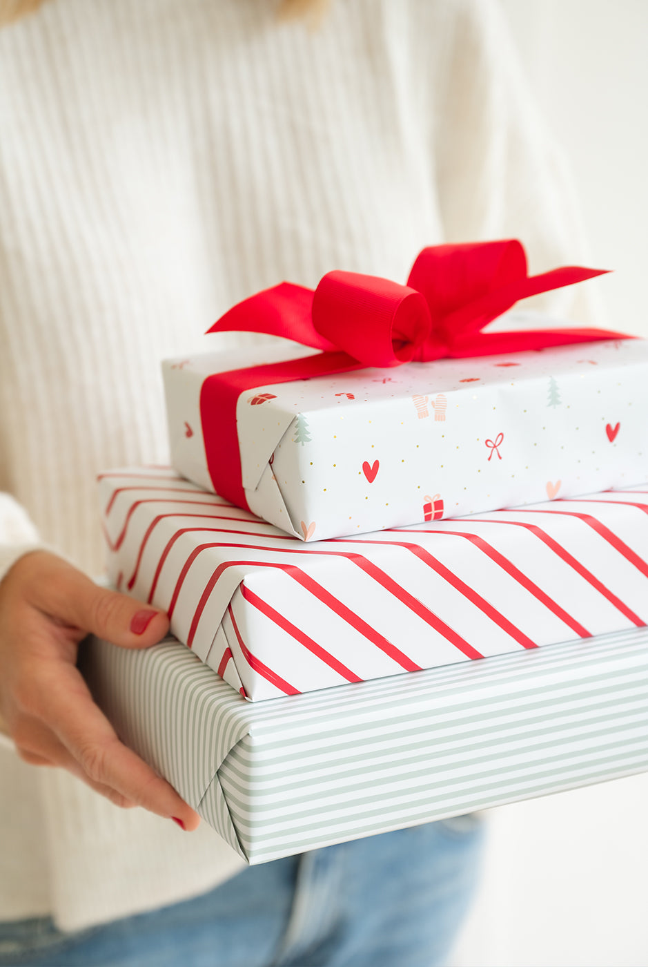 Stack of wrapped gifts held by a model.