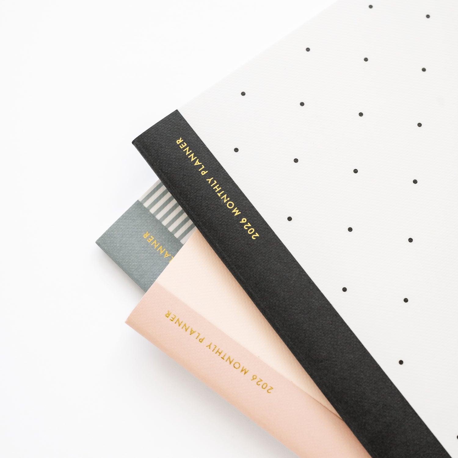 stack of monthly planners showing tape with gold foil 2026 monthly planner
