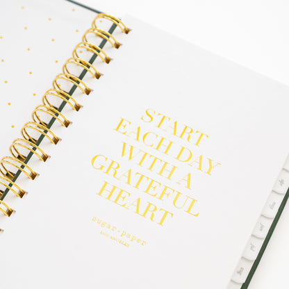 Closeup of small spiral planner quote page with 'start each day with a grateful heart'