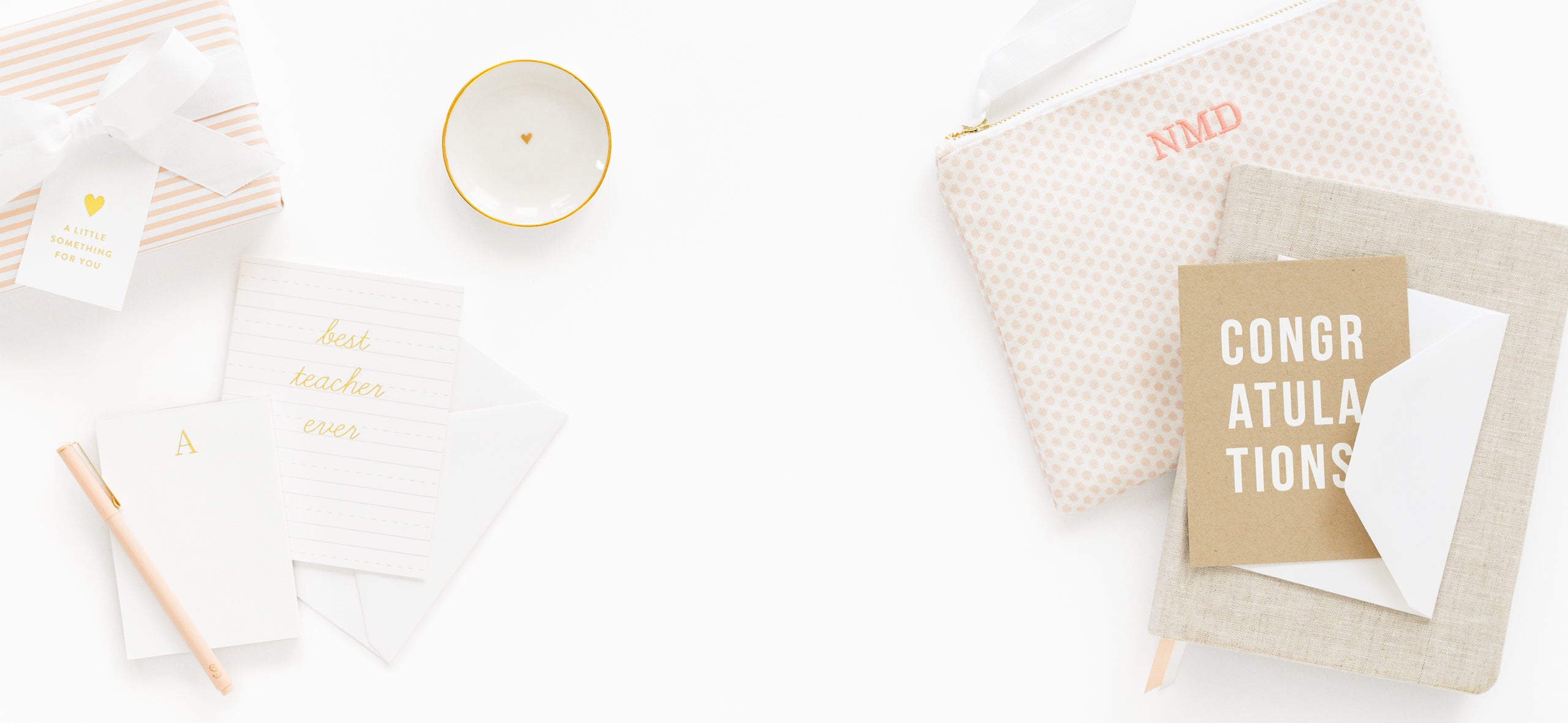 Greeting cards, a small gift, and a tray on a white surface