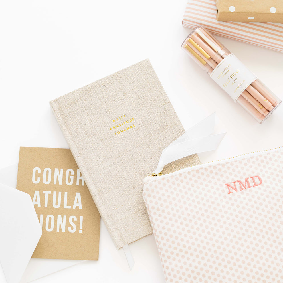 Stationery items including notebooks and a pouch on a white surface