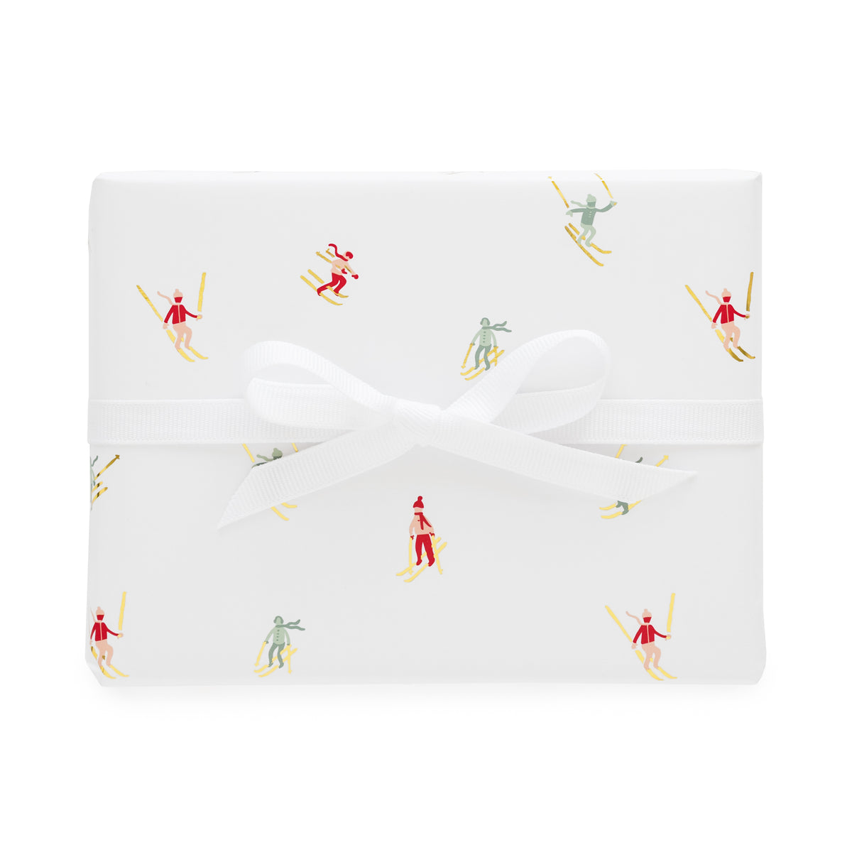 Wrapped gift with white with gold foil, red, pink and green skier pattern tied with a white ribbon bow