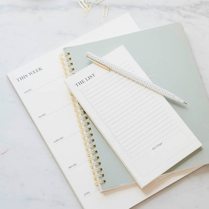 Black and cream list pads with pen and green notebook